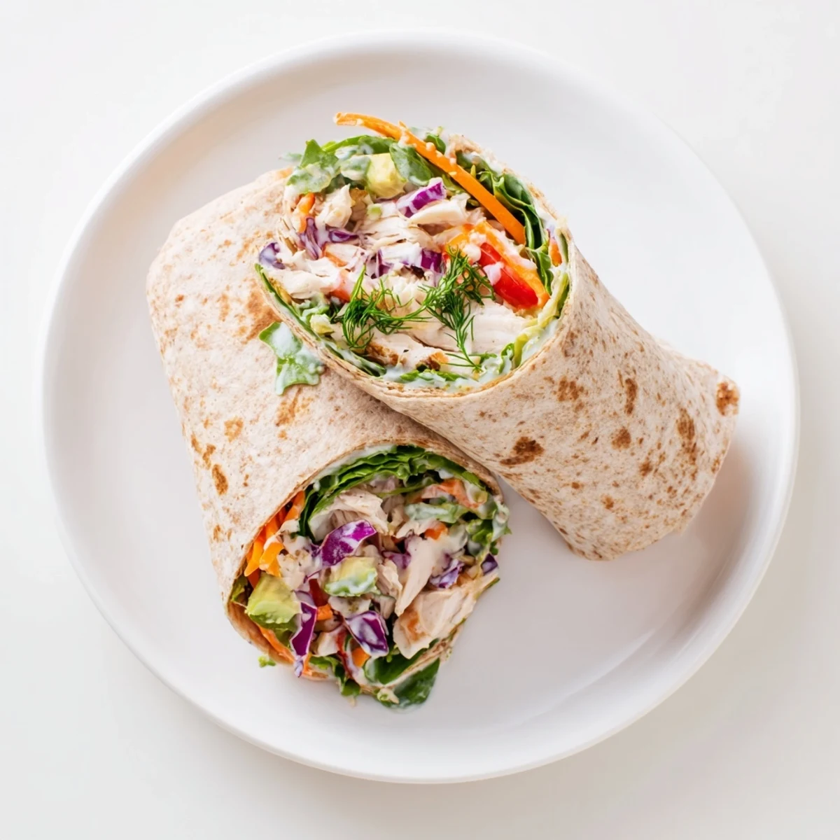 Poppy-Inspired Chicken Salad Wraps, a hearty lunch, show colorful vegetables nestled in soft tortillas.