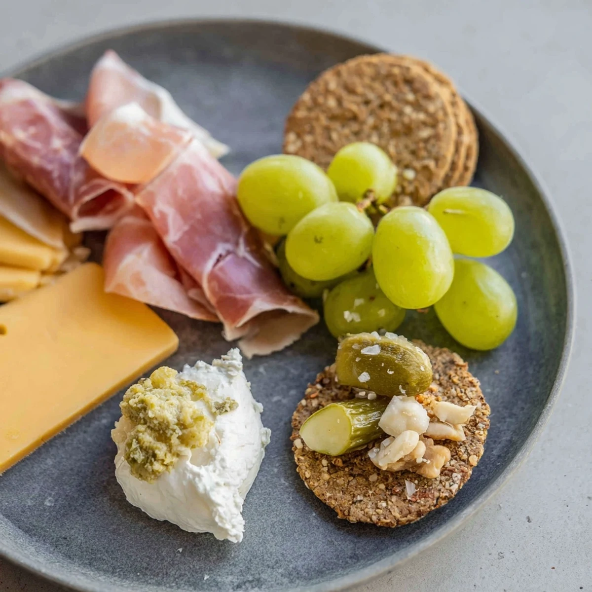 A visually appealing The Charcuterie Board for One featuring prosciutto, brie, and yummy accompaniments.