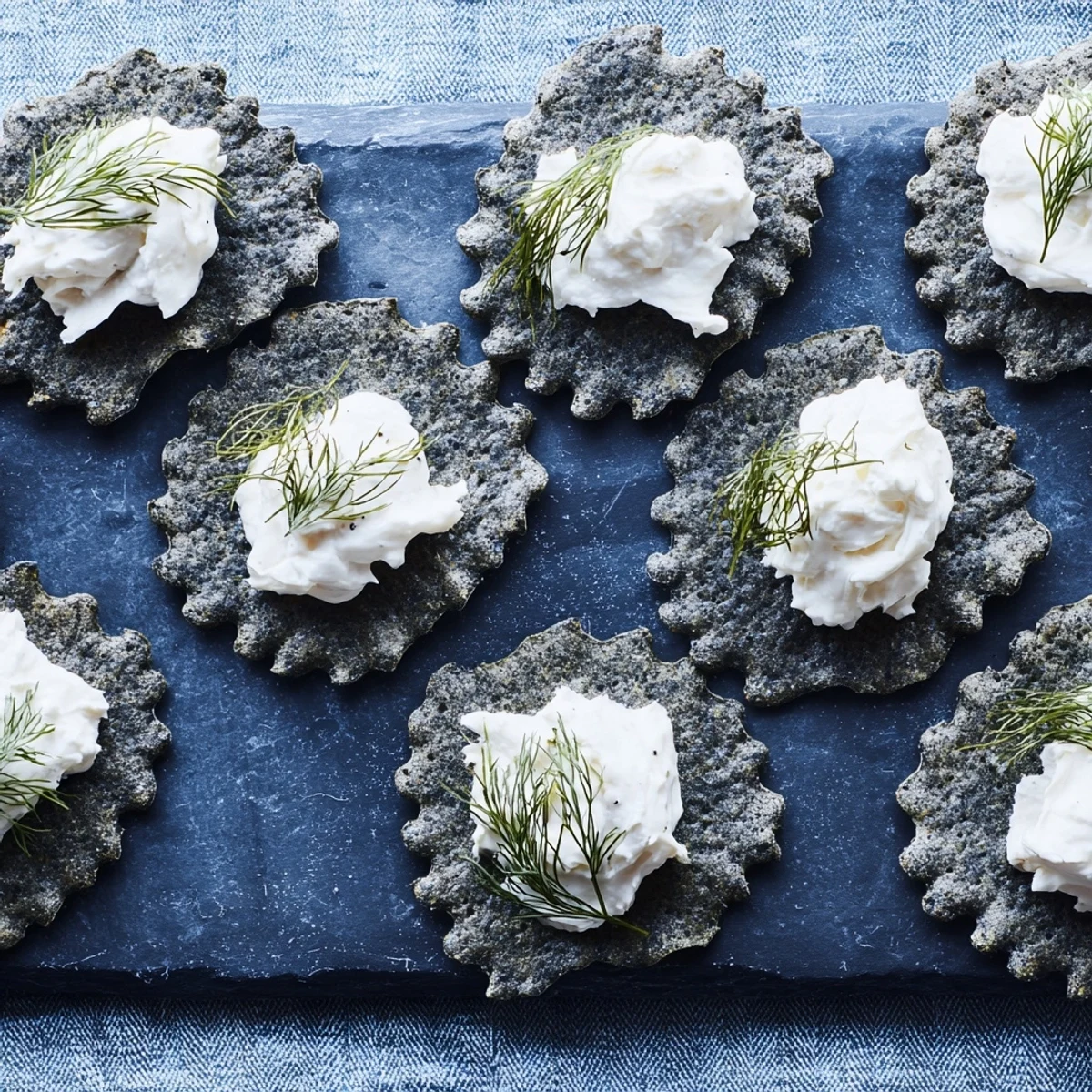 Tangy goat cheese "whitecaps" topping wavy charcoal crackers create appetizer The Stormy Sea.