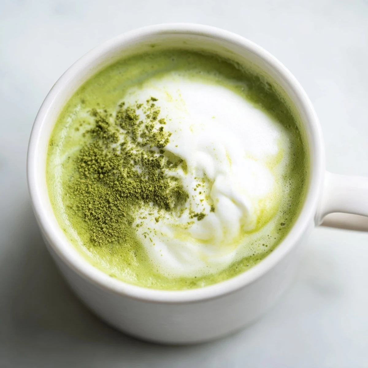 Homemade Matcha Green Tea Latte topped with a delicate layer of foam, perfect for an energizing morning.