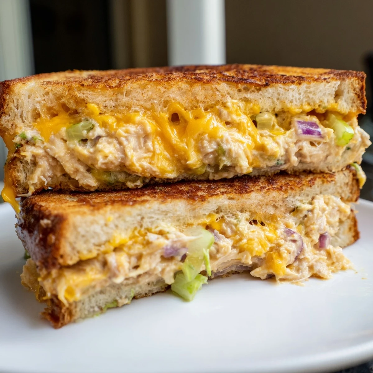 Close-up of a warm Spicy Tuna Melt sandwich, highlighting the spicy tuna salad, melted cheese, and crispy buttery sourdough crust.