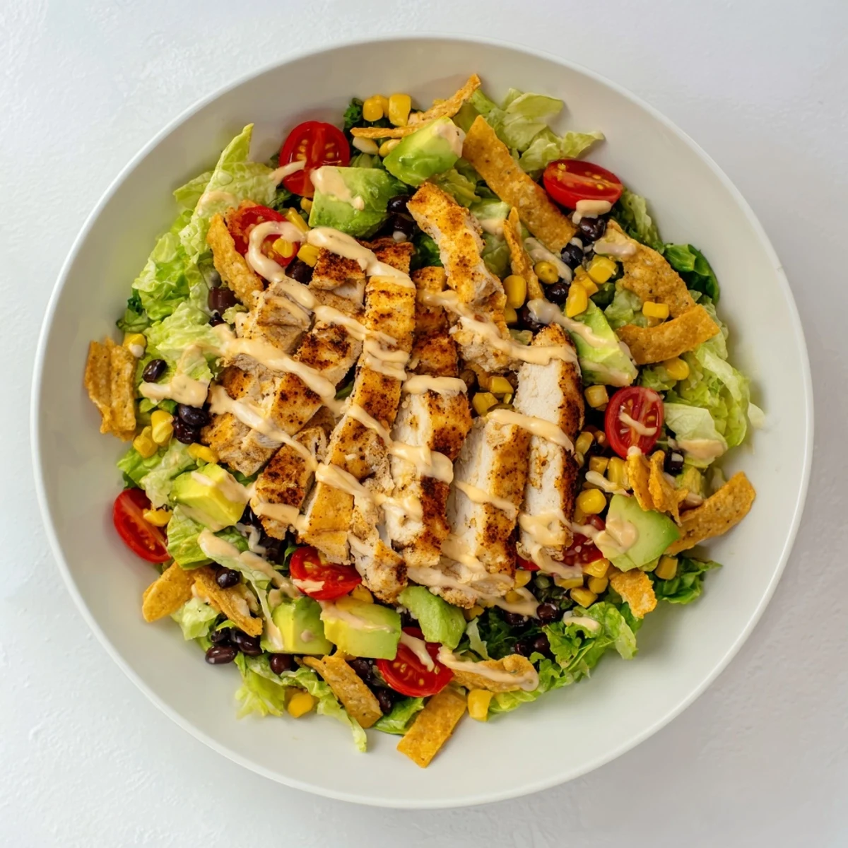 Bright green romaine and red cherry tomatoes make this Crunchy Taco Chicken Salad a colorful, Tex-Mex inspired meal.