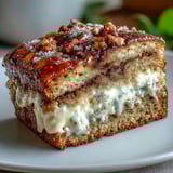 A thick slice of Cream Cheese Cinnamon Swirl Banana Bread on a plate with a cup of coffee, highlighting the moist interior.