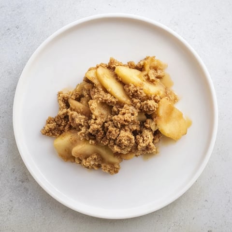 Golden-brown baked Warm Rustic Apple and Cinnamon Crumble, bubbling and ready to serve with ice cream.