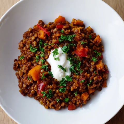 Steaming bowl of Wheat-Warm Hearty Lentil Curry, with vibrant veggies and fresh cilantro garnish, ready to eat.