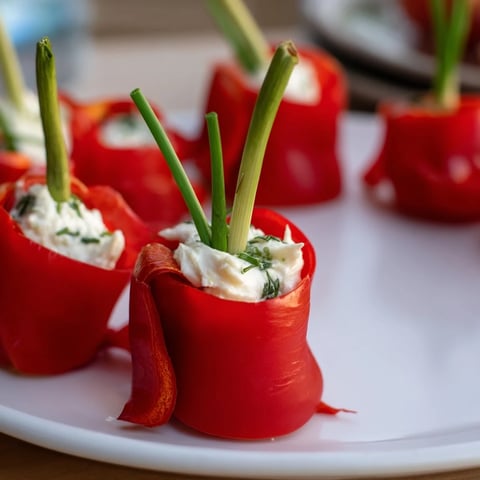 Bright red and yellow Bell Pepper Christmas Bow appetizers sit ready to eat, a holiday treat.