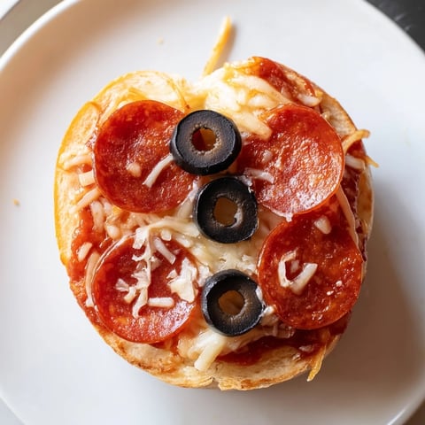 Santa Belt Mini Pizza Bites with melted mozzarella, pepperoni belts, and olive buckles, ready to eat.