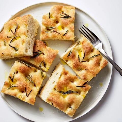 Sliced Holiday Bread focaccia with rosemary, a golden crust, and airy, soft interior.