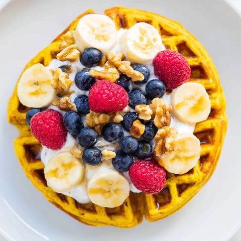 Golden, fluffy Anti-Inflammatory Adaptogenic Turmeric Waffles fresh from the iron, glistening with a light coconut oil sheen.