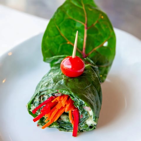 Freshly prepared Holly Leaf Spinach Wraps reveal colorful carrot and red pepper fillings inside.