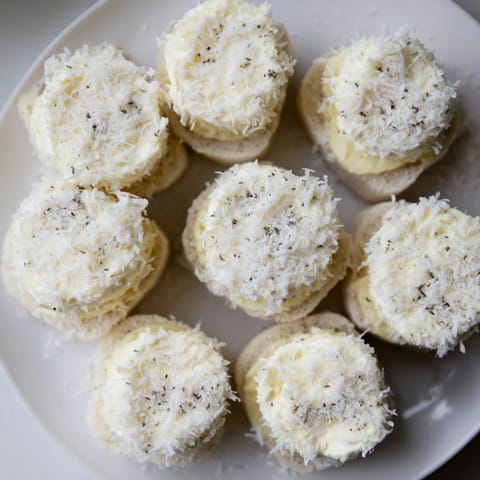 Creamy filling bursting from these snowball tea sandwich bites, lightly dusted with sweet coconut.
