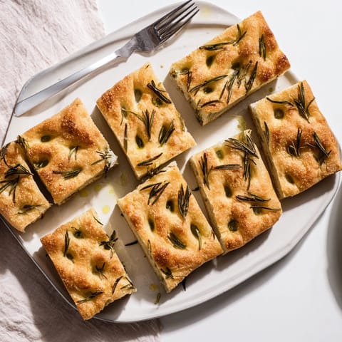 This warm, crusty Holiday Bread focaccia is garnished with sprigs of fresh rosemary and sea salt.