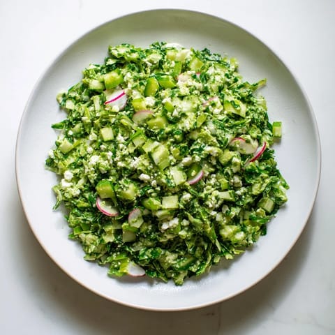 This image showcases a refreshing bowl of Green Goddess Cabbage Dip, perfect for dipping tortilla chips.