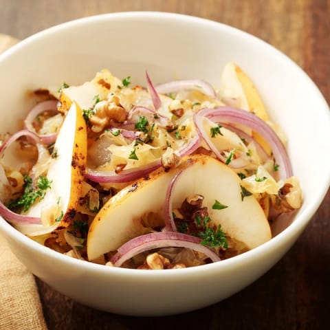 A hearty bowl of Warm Apple and Sauerkraut Skillet Salad garnished with fresh parsley, ideal as a gut-friendly side dish.