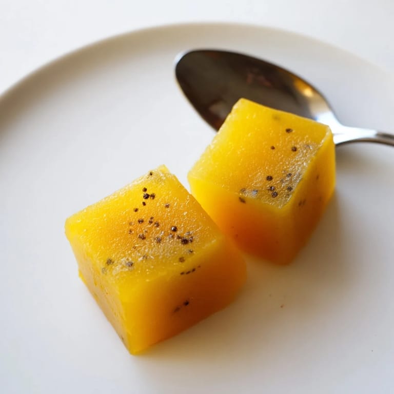 Clear ice cube tray filled with zesty Lemon Ginger Turmeric Wellness Cubes, glistening with citrus and earthy turmeric, perfect for healthy detox drinks.