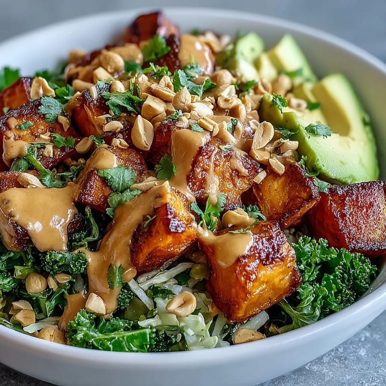 A drizzle of rich peanut sauce coats roasted sweet potatoes and fresh vegetables in this delicious Thai Peanut Sweet Potato Buddha Bowl.