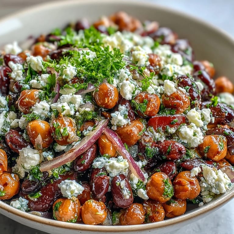 Tangy chickpea and black bean salad with red onion, feta, and parsley, ideal for quick dinners.