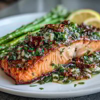 Garlic butter salmon with asparagus, golden fillets seared and bathed in rich, garlicky sauce with bright lemon and crisp-tender vegetables.